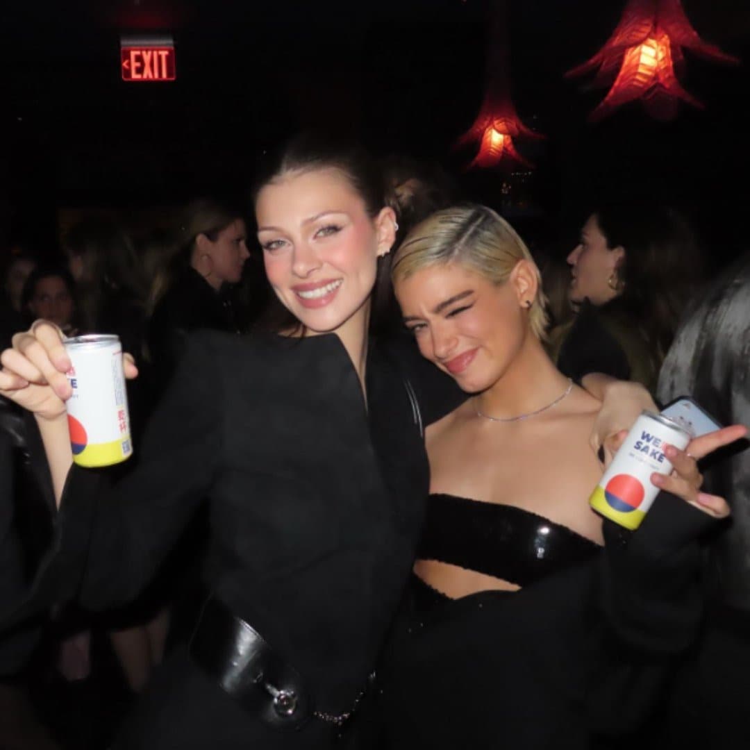 Two women holding cans of WESAKE at a launch event